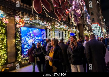 Migliaia di visitatori affollano Saks Fifth Avenue a New York per vedere la loro vetrina natalizia famosa in tutto il mondo e la collaborazione di Saks con Dior per il loro spettacolo di luci, mercoledì 22 novembre 2023 (© Richard B. Levine) Foto Stock