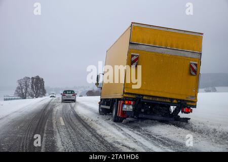 Baden-Wurttemberg, Germania. 28 novembre 2023, Baden-Württemberg, Böhmenkirch: Un camion è bloccato in un fosso su una strada statale ricoperta di neve. L'inizio dell'inverno ha causato incidenti e disagi sulle strade in alcune zone del Baden-Württemberg. Alberi caduti, strade ghiacciate e neve causarono problemi, soprattutto nelle parti più alte dello stato. Foto: Alexander Wolf/dpa Credit: dpa Picture Alliance/Alamy Live News Foto Stock