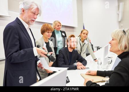 Oratore e discussione professionale mentre si è in piedi al panel durante un evento aziendale Foto Stock
