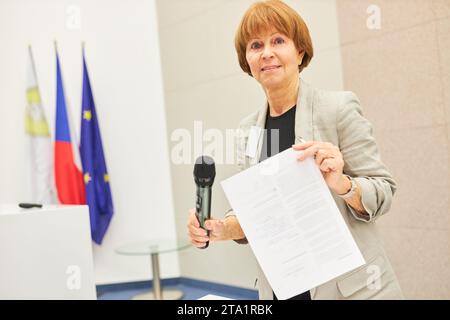 Ritratto di una oratrice matura che mostra un documento mentre si trova sul palco durante un seminario di lavoro al centro congressi Foto Stock