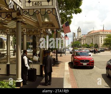 Washington, DC - 02 giugno 2018: Portiere dell'hotel e taxi rosso vicino all'hotel nel centro di Washington, DC. Foto Stock