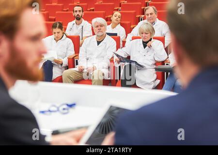 I medici in pubblico ascoltano l'oratore sul palco della conferenza medica Foto Stock