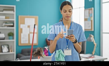Donna afro-americana professionale che usa lo smartphone in ufficio Foto Stock