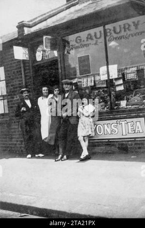 Foto in bianco e nero dei primi anni '1930 della famiglia Aubury fuori dal loro negozio di famiglia, G Aubury Fruiterer & greengrocer. Il negozio era a Battersea Park Road. Foto Stock