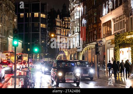 Knightsbridge, una delle zone più lussuose di Londra, in una serata umida durante l'ora di punta, West End di Londra, Inghilterra, Regno Unito Foto Stock