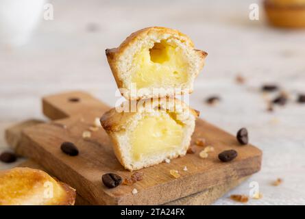 Pasticciotto leccese ripieno di crema pasticcera all'uovo, dolce tipico di Lecce, Italia. Pezzi di pasticiotto su tavola di legno, colazione pugliese Foto Stock