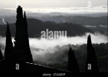 Nebbia mattutina intorno a San Gimignano, Toscana, Italia Foto Stock