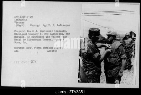 Il caporale David J. Gurlowski di Detroit, Michigan, della compagnia e, 2nd Battalion, 5th Marines, viene consegnato con la medaglia d'argento dal tenente generale Henry W. Buse Jr., il 15 maggio 1970, in Vietnam. Questa fotografia cattura la cerimonia alla quale partecipano i membri della 1st Marine Division. Foto Stock