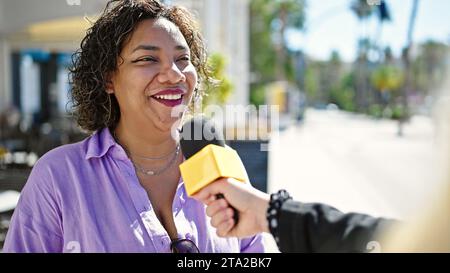 Giovane bella donna latina che ha un colloquio in strada Foto Stock