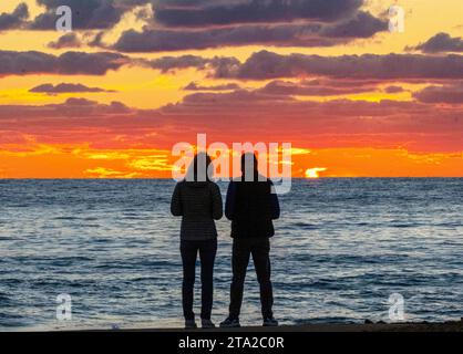 Una giovane coppia guarda il tramonto sul Mar Mediterraneo, Paphos, Cipro Foto Stock