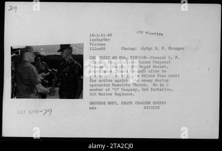 Il generale L. F. Chapman si congratula con il caporale Lance Thomas H. Murphy, membro della compagnia "l'", 3rd Battalion, 5th Marine Regiment, dopo avergli consegnato la medaglia d'argento per le sue azioni durante l'operazione Mamaluke Thrust. Foto scattata l'11 gennaio 1969 a An Hoa, Vietnam. Foto Stock