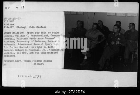 Didascalia fattuale: Ufficiali e funzionari che partecipano a un briefing congiunto durante la guerra del Vietnam nel 1967. In prima fila da sinistra a destra: Generale William C. Westmoreland, comandante generale del Military Assistance Command Vietnam, segretario alla difesa Robert M. McNamara e tenente generale Myer, U.S. Air Force. Nella seconda fila da destra a sinistra: Generale Robert E. Cushman Jr., comandante generale del III MAF, insieme a due ufficiali non identificati. Foto del Dipartimento della difesa di D.E. Brodale. Foto Stock