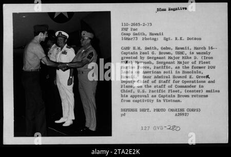 Il capitano Paul G. Brown, ex prigioniero di guerra, è accolto dal sergente maggiore Mike D. Mervosh a Honolulu, Hawaii, il 16 marzo 1973, durante l'operazione Homecoming, osservata dal contrammiraglio Howard E. Greer. Foto Stock