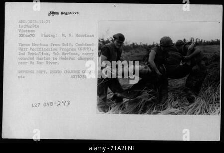 Tre membri del Combined Unit Pacification Program (CUPP), 2nd Battalion, 5th Marines - noto come Golf, portano un Marine ferito su un elicottero Medevac vicino al fiume Be Ren in Vietnam il 23 dicembre 1970. Questa immagine cattura gli sforzi di evacuazione medica effettuati dai militari durante la guerra del Vietnam. Foto Stock