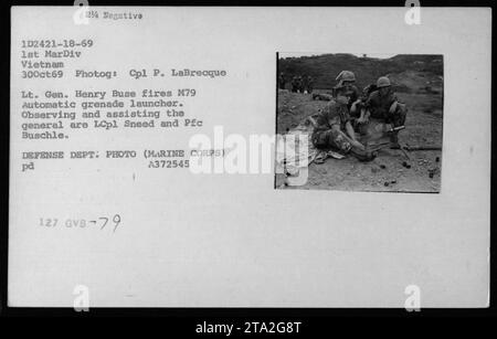 L'assistente segretario della Marina John Warner, il segretario alla difesa Melvin Laird e il dottor Norman Vincent Peale partecipano a una cerimonia nel 1969. Il tenente generale Henry Buse spara un lanciagranate automatico M79 mentre LCpl Sneed e PFC Buschle osservano e assistono. Questa foto è stata scattata in Vietnam dal Marine Corps Cpl P. LaBrecque il 30 ottobre 1969. Foto Stock