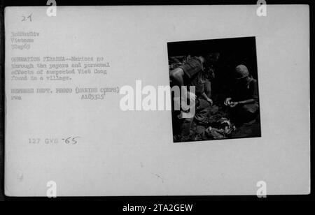 I soldati della 3rd Marine Division in Vietnam sono visti mentre cercavano tra gli effetti personali e i documenti del sospetto Viet Cong trovato in un villaggio durante l'operazione Piranha il 7 settembre 1965. Stanno esaminando attrezzi catturati come cibo, bandiere e altri rifornimenti. Questa fotografia in bianco e nero è stata scattata dal Dipartimento della difesa ed è etichettata come A185315 127 GVB-65. Foto Stock