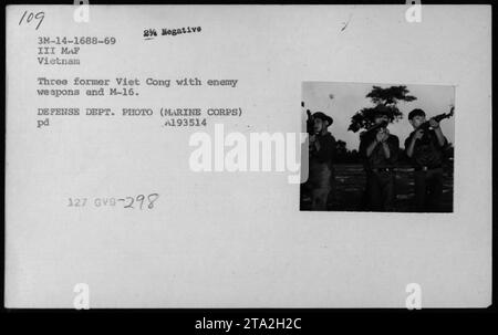 Tre ex soldati Viet Cong, noti come Kit Carson Scouts, si schierano con armi nemiche e fucili M-16 durante la guerra del Vietnam. Questa foto, intitolata "Reformed Viet Cong (Kit Carson Scouts) - 1969", è stata scattata da un fotografo del Dipartimento della difesa del corpo dei Marines. Foto Stock