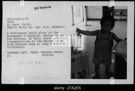 Un bambino vietnamita gioca nel terminal passeggeri della Marine Corps Air Station, El Toro, in attesa del trasporto al campo profughi di Camp Pendleton il 6 marzo 1975. La foto mostra la realtà dei rifugiati vietnamiti durante la guerra del Vietnam. Foto Stock