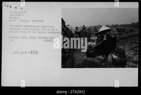 Le truppe marine conducono l'operazione Mississippi nel dicembre 1966, come si vede in questa immagine. I rifugiati civili vengono evacuati dalla Valle di Antanas, mentre i Marines continuano la loro presenza nella zona. Questa fotografia è stata scattata dal fotografo Outerann e fa parte di una serie che cattura le attività militari americane durante la guerra del Vietnam. Foto Stock