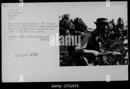 Il caporale Dennis Clayton della 'A' Company, 3rd Recon, 3rd Platoon, è visto in pattuglia durante le attività di ricognizione nel 1967. Nella foto, tiene in mano il fucile, pronto per il combattimento, e ha una radio legata alla schiena. Questa immagine cattura la dedizione e la prontezza del personale militare americano durante la guerra del Vietnam. Foto Stock