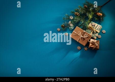 Sfondo natalizio. Scatole regalo nastri legati e decorazioni natalizie su sfondo turchese. Foto Stock