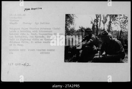 Il sergente maggiore Charles Awkerman (a sinistra) tiene un briefing con il tenente colonnello John A. Dowd, ufficiale comandante, 1st Battalion, 7th Marines, durante una pausa di combattimento durante l'operazione Oklahoma Hills, 11 miglia a sud-ovest di da Nang. 1° maggio 1969. Fotografato dal sergente Mullins. Questa è una foto ufficiale del Dipartimento della difesa. Foto Stock