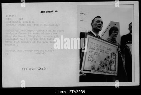 Il capitano Allen Colby Brady riceve un regalo dall'HC-6 Enlisted Wives Club presso lo U.S. Naval Hospital durante l'operazione Homecoming il 20 marzo 1973. Foto Stock