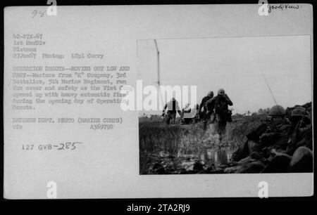 I Marines della compagnia "K", 3rd Battalion, 5th Marine Regiment, cercano copertura mentre i Viet Cong si impegnano in un pesante fuoco automatico il primo giorno dell'operazione Deaviera. Questa fotografia è stata scattata il 27 gennaio 1967 da LCpl Curry durante le pattuglie condotte dalla 1st Marine Division in Vietnam. Foto Stock