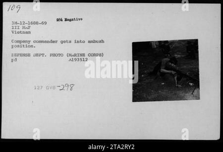 Il comandante della compagnia dei Marine Corps assume una posizione di imboscata durante la guerra del Vietnam. Questa foto cattura un membro riformato dei Viet Cong, noto anche come Kit Carson Scout, che assiste le forze americane nello svolgimento delle loro missioni. L'immagine è indicata come numero 298 nella collezione fotografica del Dipartimento della difesa degli Stati Uniti. Foto Stock