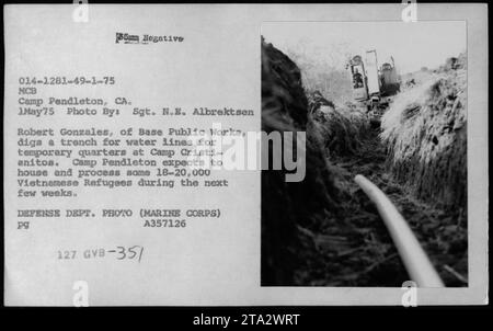 Gli uomini della base Public Works di Camp Pendleton, CALIFORNIA, scavano una trincea per le linee d'acqua a Camp Cristianitos il 1° maggio 1975. Questo campo prevede di accogliere e processare circa 18-20.000 rifugiati vietnamiti nelle prossime settimane. Fotografo: Sgt. N.E. Albrektsen, Dipartimento della difesa. Riferimento immagine: 014-1281-49-1-75. Foto Stock