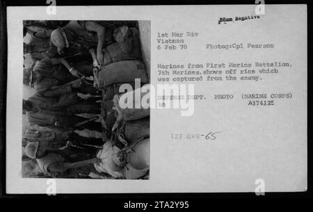 Marines del primo Battaglione dei Marines, 7th Marines, che mostravano rifornimenti catturati dal nemico, compresi sacchi di riso. La foto, scattata dal colonnello Pearson, mostra l'equipaggiamento catturato il 6 febbraio 1970, durante la guerra del Vietnam. Fonte: Foto del Dipartimento della difesa dagli archivi del corpo dei Marines. Foto Stock