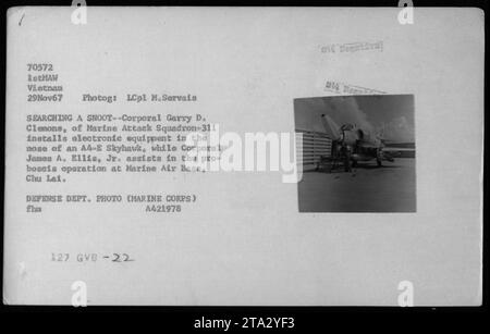 Il caporale Garry D. Clemons e il caporale James A. Ellis Jr. Installano apparecchiature elettroniche nel naso di un aereo A-4E Skyhawk presso la base aerea di Chu Lai. Questa operazione ebbe luogo il 29 novembre 1967, durante la guerra del Vietnam. L'immagine è stata scattata da LCpl M.Servais. Foto Stock