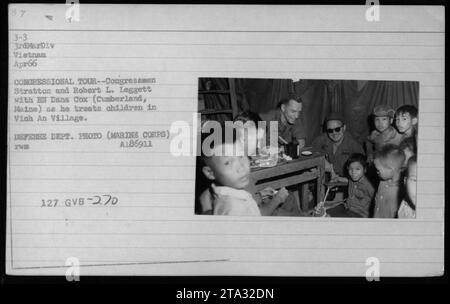 I membri del Congresso Stratton e Robert L. Leggett accompagnano HN Dana Cox da Cumberland, Maine, durante un tour congressuale a Vinh An Village, Vietnam, nell'aprile 1966. Nella foto, Cox può essere visto trattare bambini mentre ufficiali e funzionari, tra cui il presidente Lyndon Johnson e il colonnello P X Kelley, osservano le attività. Foto Stock