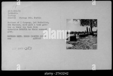 I Marines della i Company, 3rd Battalion, 9th Marines passano davanti a una porta tombale dopo aver completato l'operazione BARBELL il 25 ottobre 1965, in Vietnam. Foto Stock
