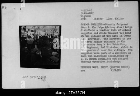 Didascalia: Il sergente John B. Kerridge aiuta a distribuire forniture scolastiche e bambole ai civili nel villaggio di tra Kieu nella provincia di Quang Ngai, Vietnam, nel 1965. I rifornimenti facevano parte di una spedizione contribuita dai cattolici romani statunitensi e distribuita attraverso l'operazione Handclasp. (Fotografo: LCpl. Hallas, foto del Dipartimento della difesa A184981) Foto Stock