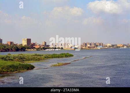 Giza, Egitto, 9 settembre 2022: Il fiume Nilo in Egitto, con edifici di un villaggio a Giza sulla sua costa, il Nilo è un grande fiume che scorre a nord Foto Stock