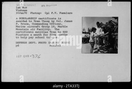 CPL F.V. Famularo scattò questa foto il 30 gennaio 1970, durante la guerra del Vietnam. Mostra il colonnello James P. Bruce, ufficiale comandante del Marine Aircraft Group 16, che assegna una borsa di studio a Tran Thong, un civile vietnamita. Il certificato dà diritto a Tran di ricevere 500 piaster al mese per cinque mesi per assistere nel pagamento delle lezioni scolastiche. Questa immagine è stata rilasciata dal Dipartimento della difesa. Foto Stock