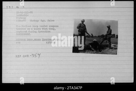 Due marines stanno di guardia su un sospetto di Viet Cong catturato durante l'operazione MONTGOMERY in Vietnam il 13 maggio 1966. I marines tengono le armi addestrate sul prigioniero per assicurarsi che sia al sicuro. Questa foto è stata scattata dal sergente Salve del corpo dei Marines degli Stati Uniti. Foto del Dipartimento della difesa (corpo dei Marines) A369106. Foto Stock