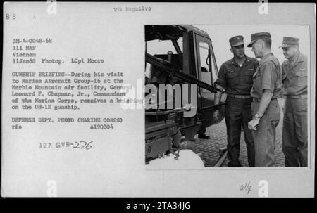 Il generale Leonard F. Chapman Jr., comandante del corpo dei Marines, riceve un briefing sulla nave da guerra UH-1E durante la sua visita al Marine Aircraft Group-16 presso la struttura aerea di Marble Mountain in Vietnam l'11 gennaio 1968. La fotografia è stata scattata da LCpl Moore e fa parte di una serie di immagini che documentano le attività militari americane durante la guerra del Vietnam. Foto Stock