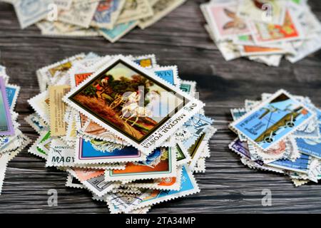 Cairo, Egitto 21 settembre 2022: Sfondo di vari vecchi francobolli usati da diversi paesi e tempi su sfondo di legno, con copertina Foto Stock