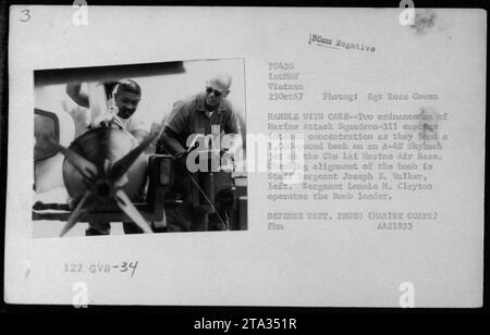 Il sergente Lonnie M. Clayton e il sergente Joseph E. Walker caricano con attenzione una bomba da 1.000 libbre su un jet A-4 Skyhawk alla base aerea di Chu Lai Marina il 23 ottobre 1967. Questa fotografia cattura l'intensa concentrazione degli ordigni del Marine Attack Squadron-311. Foto del Dipartimento della difesa (corpo dei Marines) A421933." Foto Stock