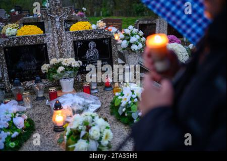 I fedeli posero fiori e candele e pregavano per i defunti sulla loro tomba. Foto Stock