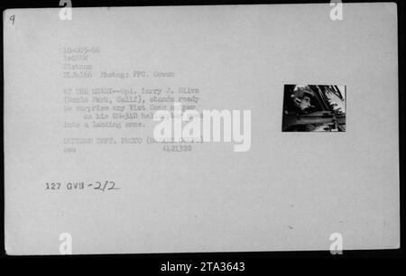 Membro del corpo dei Marines degli Stati Uniti, PFC. Larry J. Silva di Menlo Park, California, è pronto a contrastare potenziali cecchini Viet Cong mentre il suo elicottero U-34D scende per un atterraggio in Vietnam il 24 luglio 1966. Questa immagine simboleggia la vigilanza e l'attenzione dei soldati americani durante la guerra del Vietnam. Foto Stock
