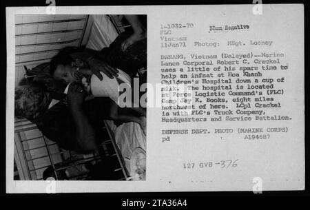 Il caporale di Marine Lance Robert C. Crackel aiuta un neonato all'Hoa Khanh Children's Hospital, situato presso il Force Logistic Command's (FLC) Camp Jay K. Books a Danang, Vietnam, l'11 gennaio 1971. LCpl Crackel, un membro della FLC's Truck Company, viene mostrato mentre aiuta il bambino a bere una tazza di latte durante il tempo libero. Questa foto è stata scattata da MSgt. Looney per il Dipartimento della difesa. Foto Stock