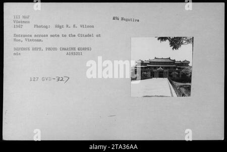 Ingresso attraverso la mote all'antica Cittadella di Hue, Vietnam. La fotografia, scattata nel 1967 durante le attività militari americane in Vietnam, mostra le strutture sia del corpo dei Marines degli Stati Uniti che degli edifici e dei bunker vietnamiti. L'immagine cattura l'ingresso fortificato con un fossato, mostrando le misure difensive intraprese durante questo periodo. Foto Stock