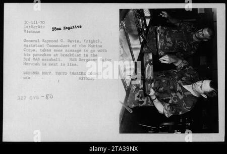 Il generale Raymond G. Davis, Assistente Comandante del corpo dei Marines, viene visto a colazione nel 3rd MAB Messhall durante il suo servizio in Vietnam. Si vede prendere la salsiccia per accompagnare i suoi pancake. Il sergente MAB maggiore Mervosh può essere visto il prossimo in fila. Questa foto è stata scattata nel 1970. Foto Stock