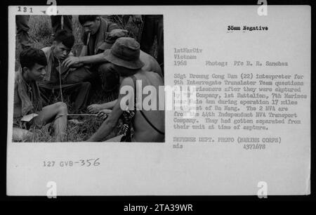 Immagine: La fotografia mostra due prigionieri di guerra vietnamiti seduti a terra, di fronte a un gruppo di soldati americani. Uno dei soldati americani, identificato come SSgt Droung Cong Dam, è visto come un interprete per i soldati che stanno interrogando i prigionieri. I prigionieri, identificati come membri della 44th Independent NVA Transport Company, furono catturati dalla compagnia "B", 1st Battalion, 7th Marines vicino a Galo Ann durante un'operazione 17 miglia a sud-ovest di da Nang. Foto Stock