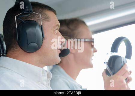 vista ravvicinata del pilota che indossa una cuffia con accompagnamento femminile Foto Stock