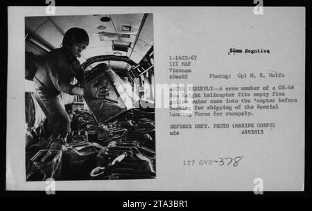 Un membro dell'equipaggio di un elicottero CH-46 Sea Knight carica lattine d'acqua vuote da cinque litri per il rifornimento. L'immagine illustra la logistica delle acque di campo e il ruolo degli impianti di depurazione in Vietnam. Foto Stock