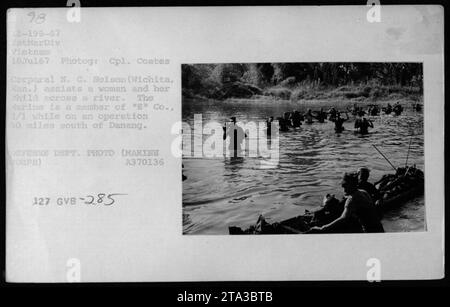 CPL. Nelson di 'e' Co., 2/1 assiste una donna e suo figlio mentre pattuglia 30 miglia a sud di Danang in Vietnam. Questa immagine è stata scattata il 18 luglio 1967 da Cpl. Coates ed è parte della collezione di attività militari americane durante la guerra del Vietnam. Foto Stock
